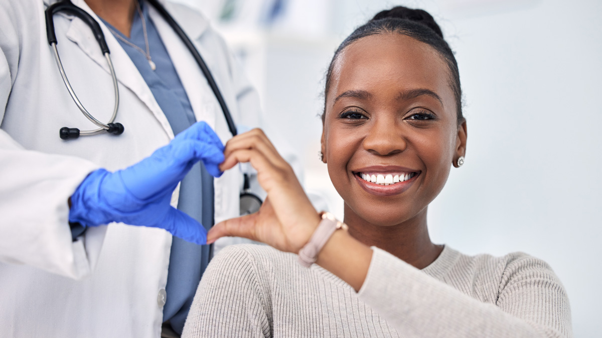 positive patient lives with doctor and patient creating a heart symbol with hands