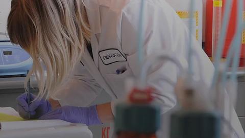 FibroGen scientist records data manually into a notebook