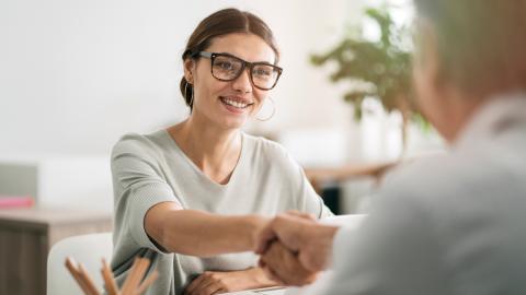 female shaking hands with another person