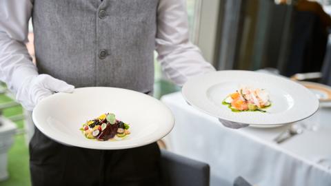 waiter carrying plates of food