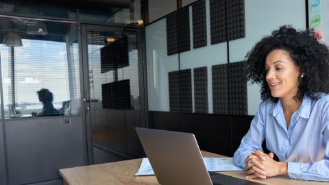 lady in office sat at desk with laptop