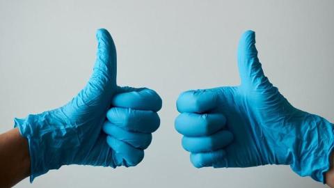 Two thumbs up in surgical gloves