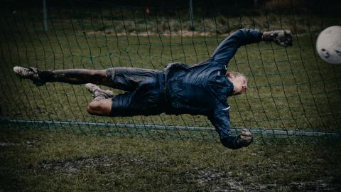 football going into the net past goalkeeper to score