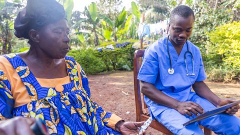 A doctor consults the prescription on his tablet and delivers drugs