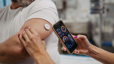 Doctor connecting continuous glucose monitor with smartphone