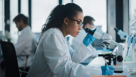 researcher in lab with microscope