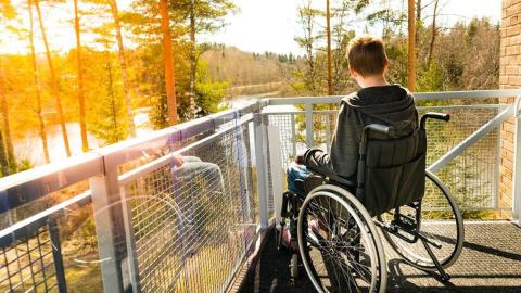 Young man in wheelchair on balcony