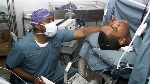 Operating theatre with nurse and patient under anaesthetic