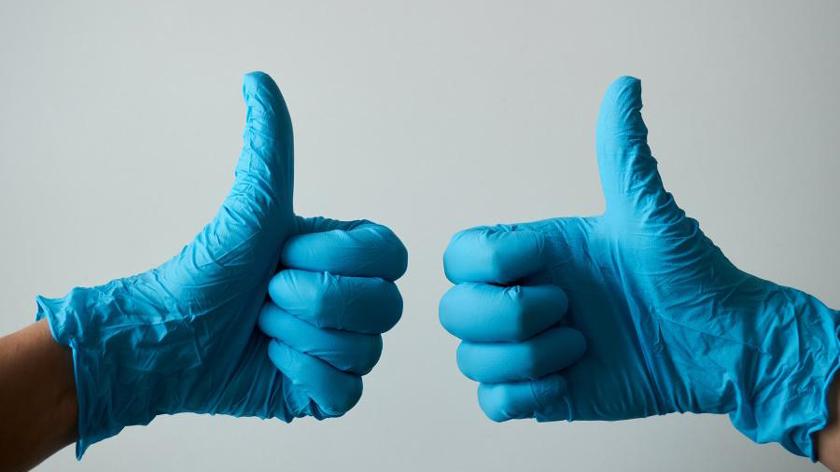 Gloved hands thumbs up