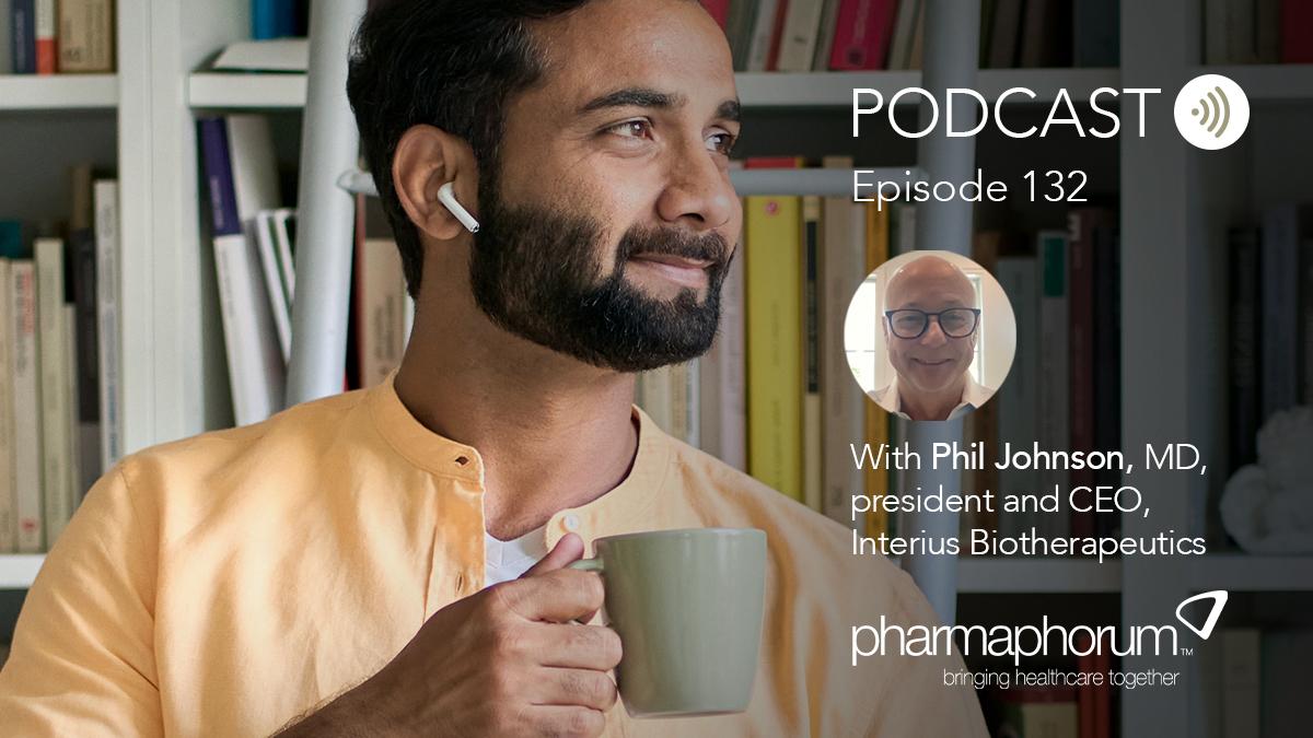 Man holding cup and listening to audio