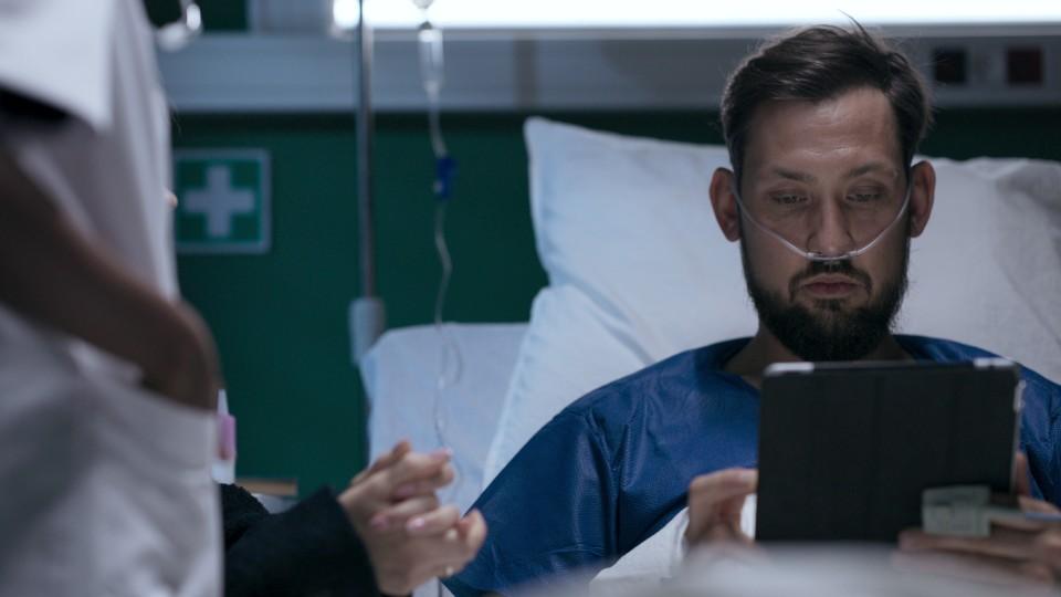 Patient in hospital bed, engaged with care information