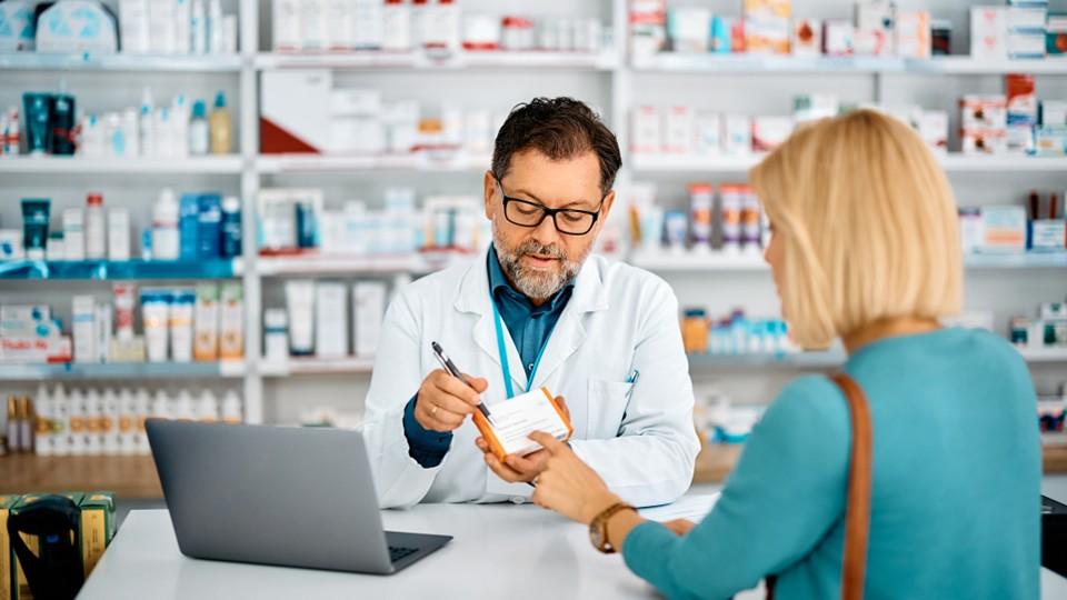 Pharmacist with patient, explaining prescription