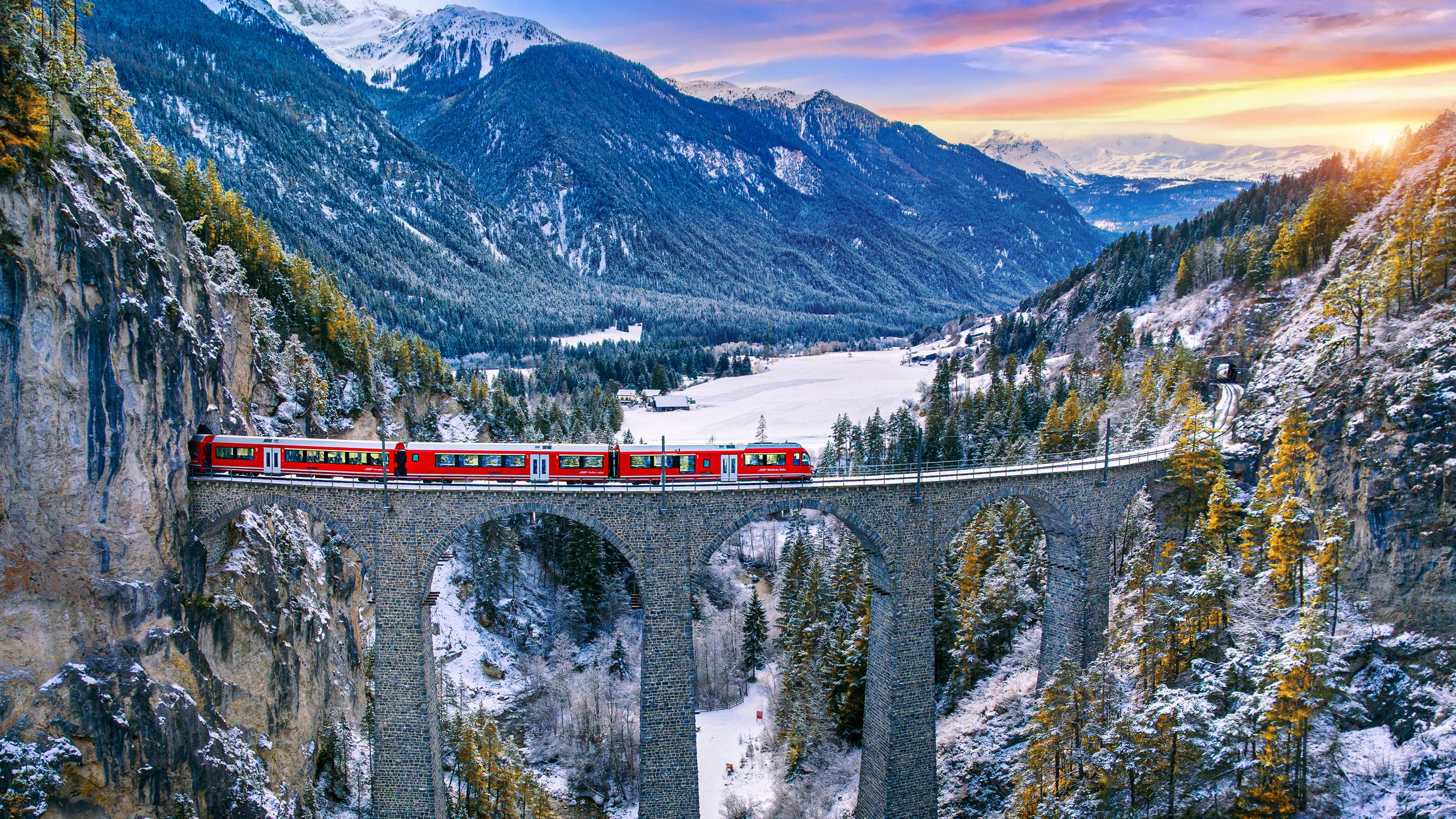 Swiss train speeding across bridge against landscape background