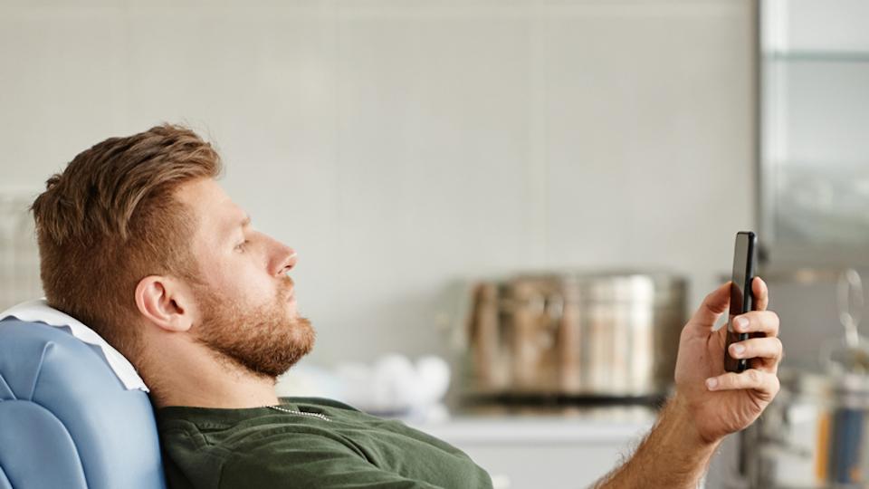 Man on his smartphone while sitting on sifa