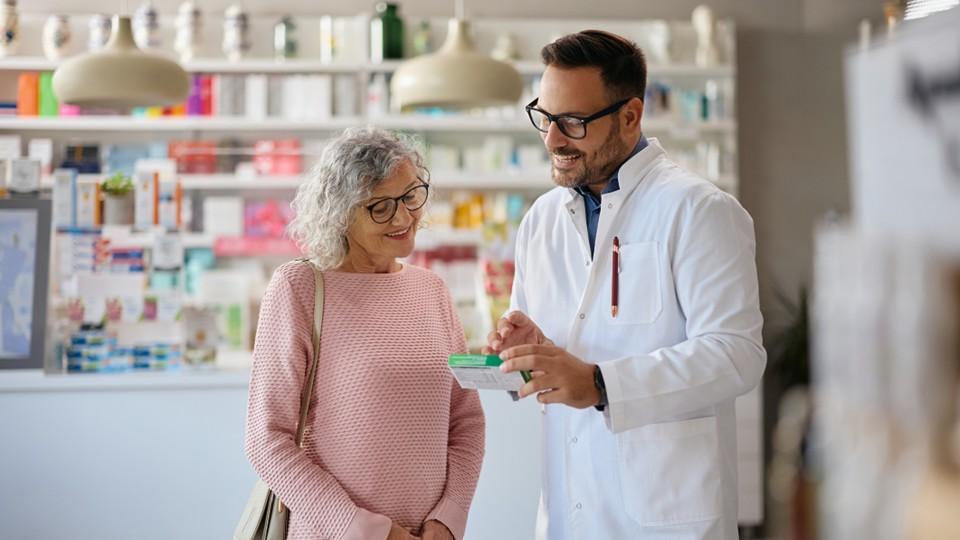 Pharmacist with patient and prescription