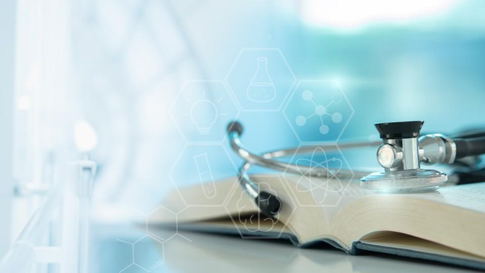 Stethoscope rests on medical textbook with AI concept overlay, light blue background