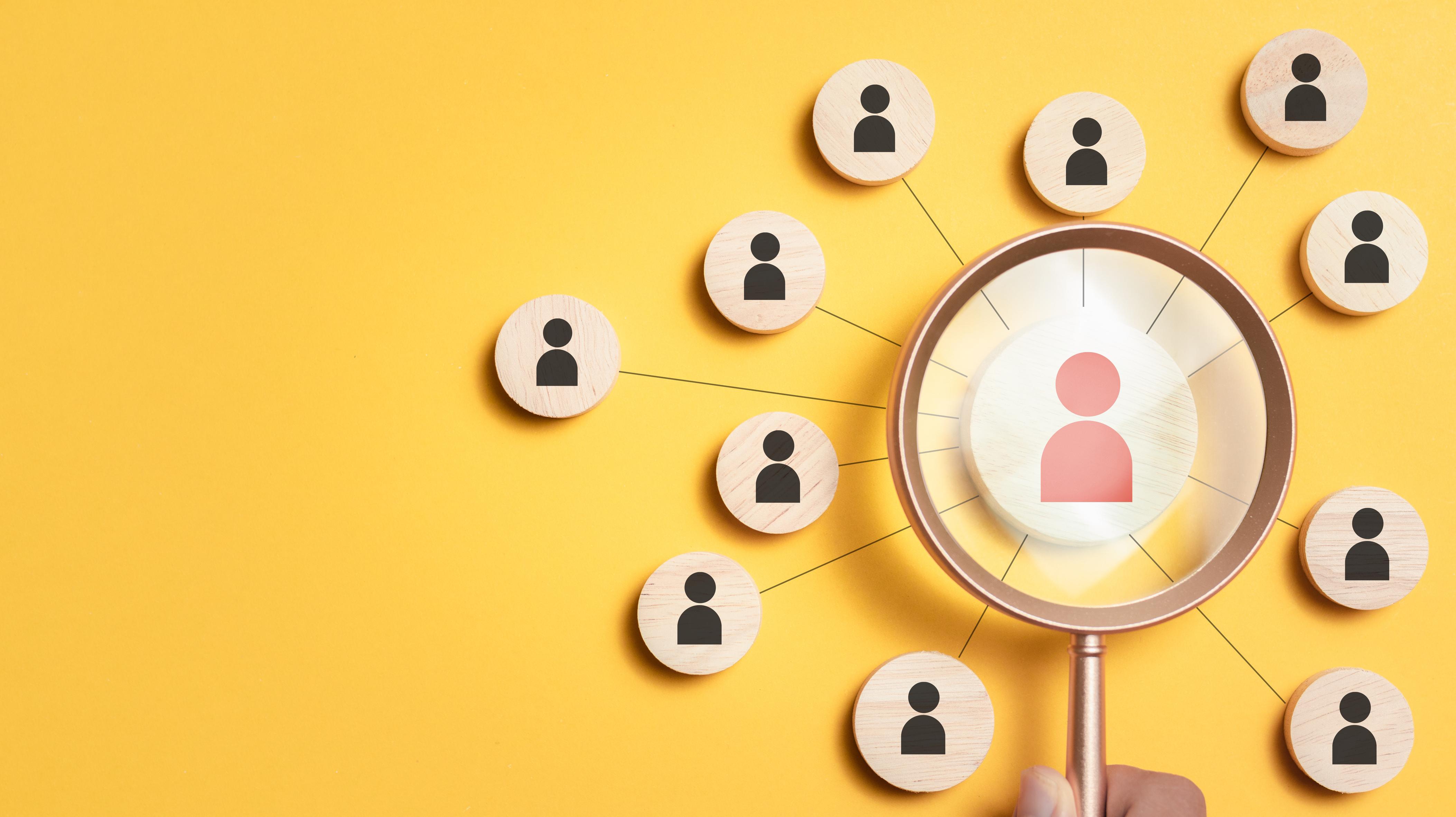 Magnifying glass over candidate profile on mustard yellow background