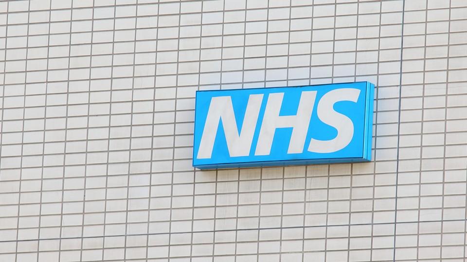 NHS sign on tiled exterior wall