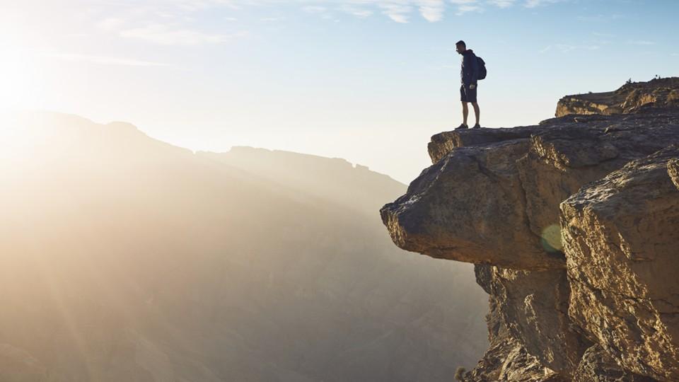 Man stands at cliff edge