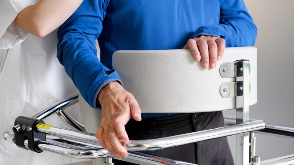 A physiotherapist assists an ALS patient