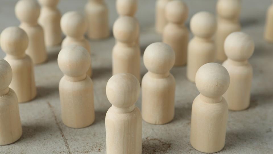 Wooden pawns representing number of employees