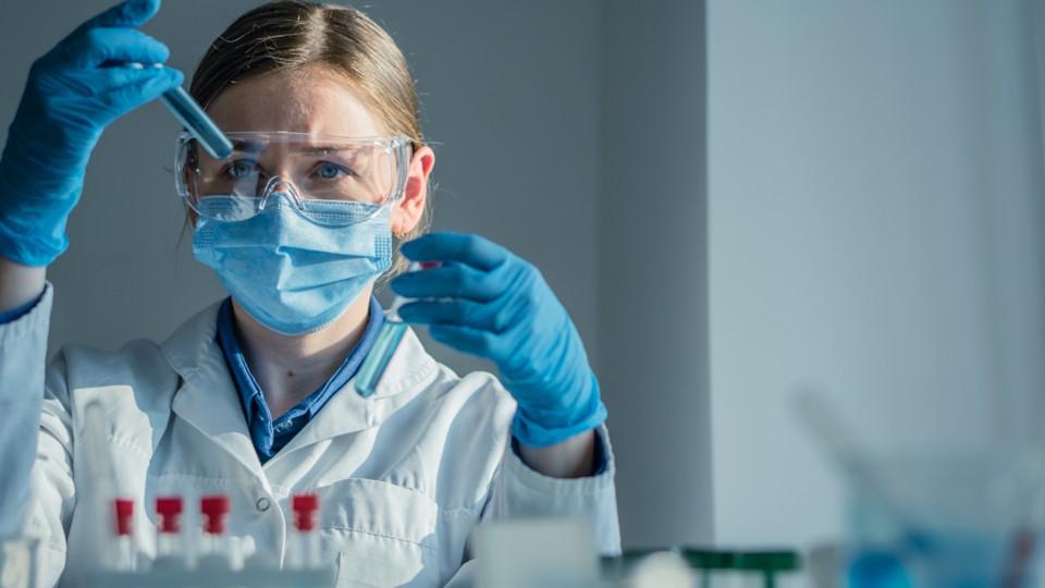 Female scientists compares test tubes results