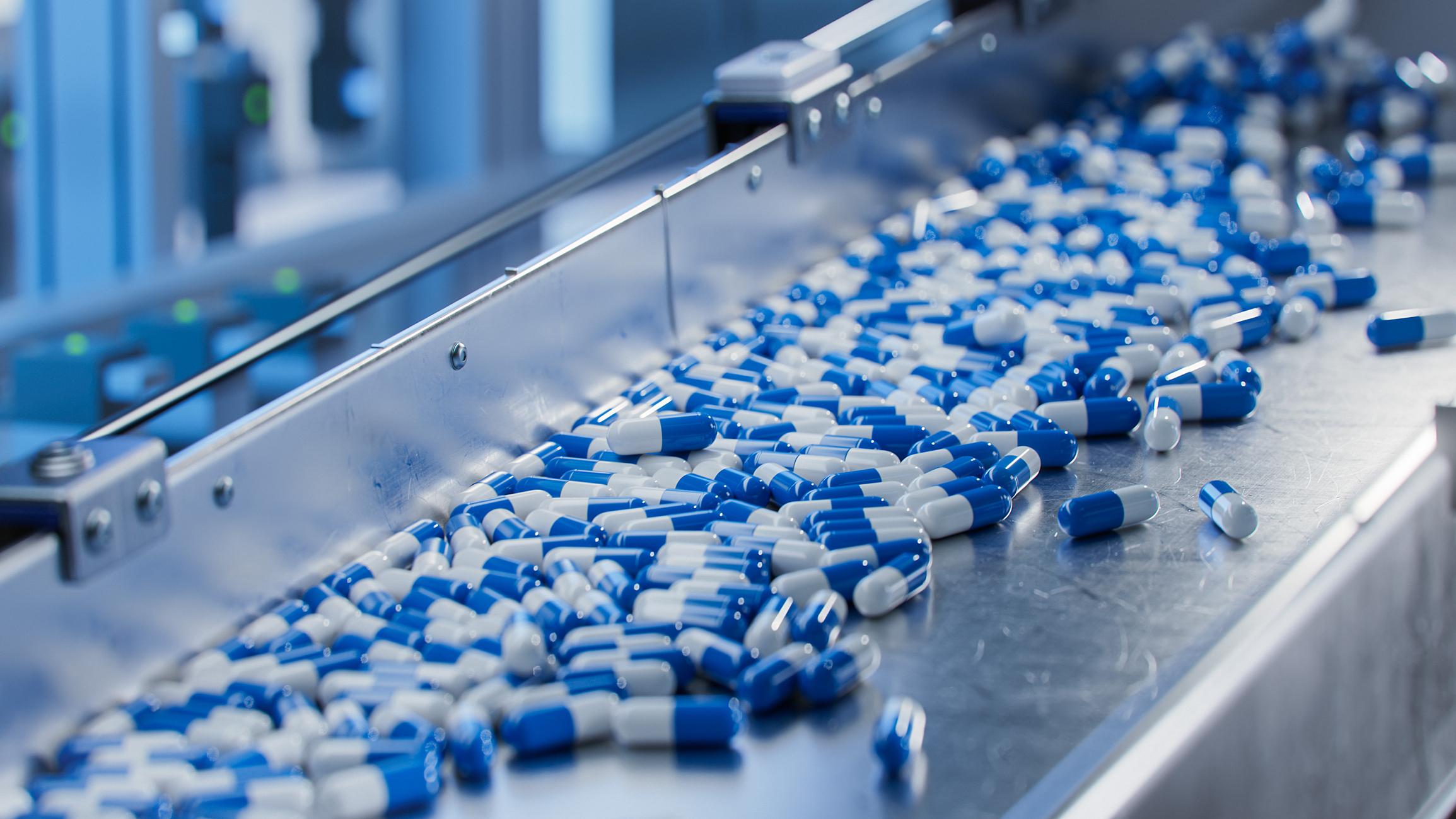 Blue and white pills in pharma manufacturing line