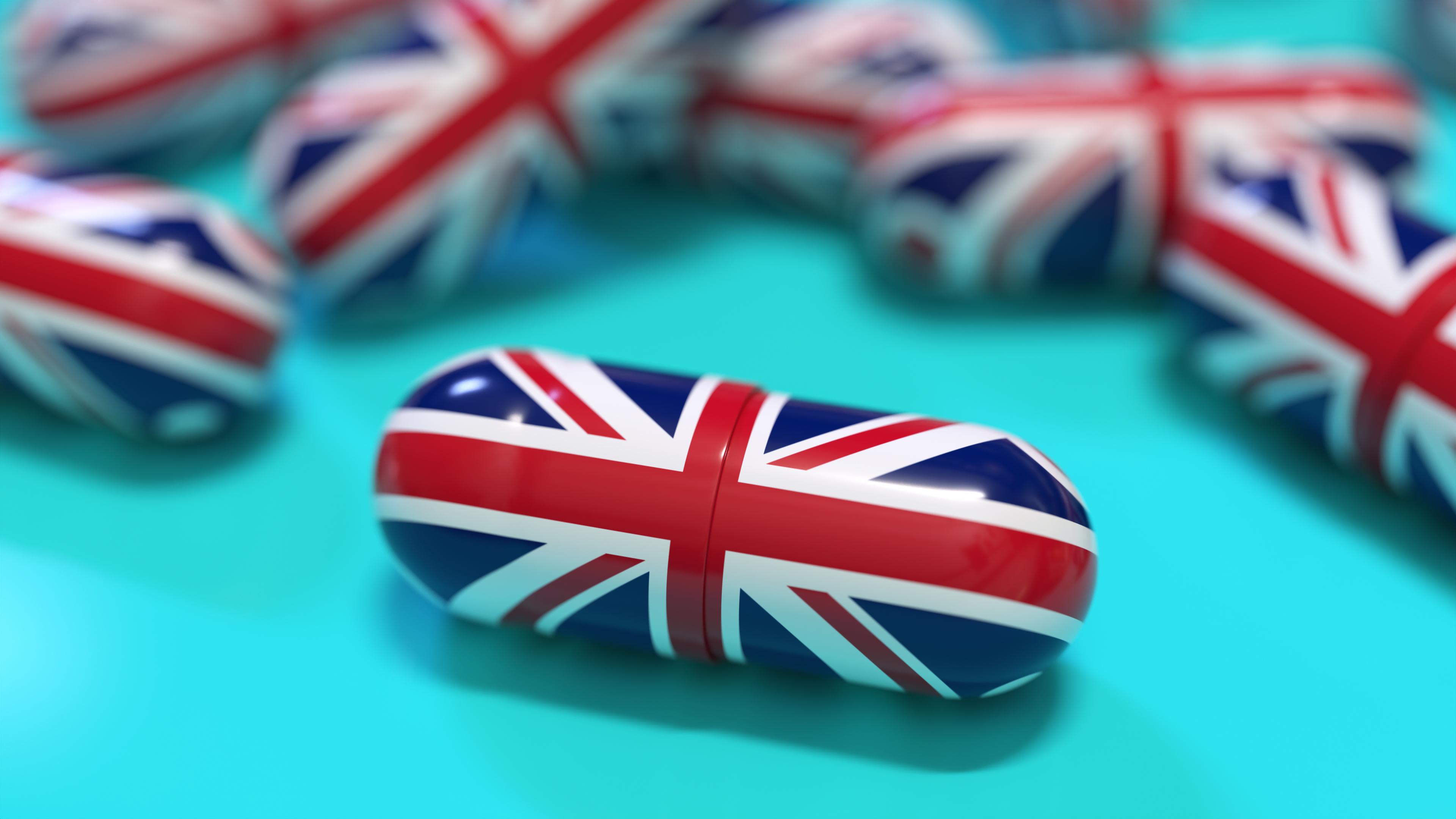 Union Jack on pill, one of many scattered on aqua surface