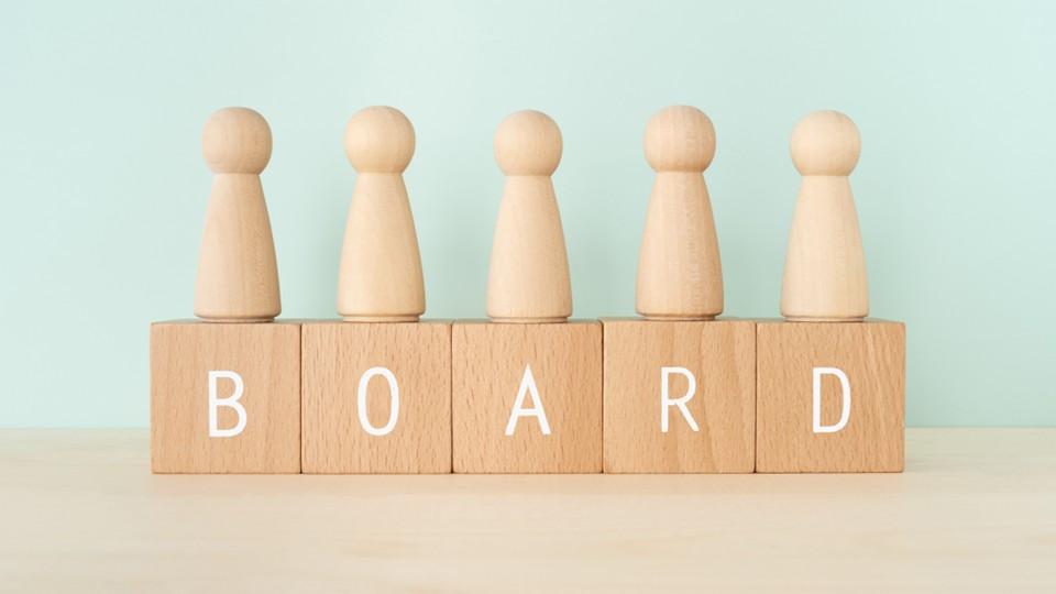 Wooden pawns on top of wooden block named BOARD