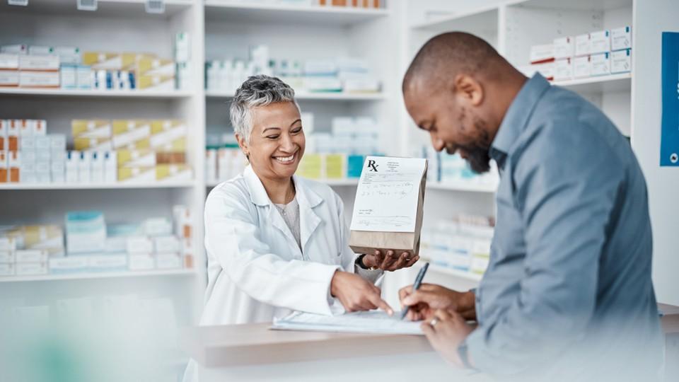 Female pharmacist with male patient in pharmacy