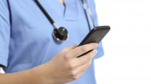 Close up of a nurse hand using a smart phone