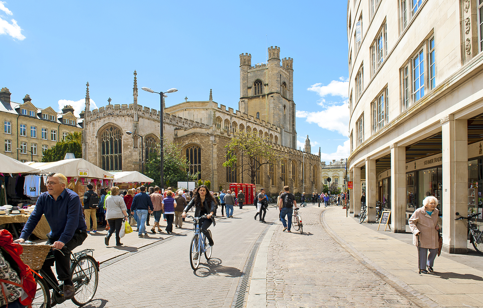 Cambridge, England - May 28, 2015: People biking at the Market square near by St. Marys church in Cambridge