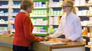 Customer receiving medication from pharmacist.