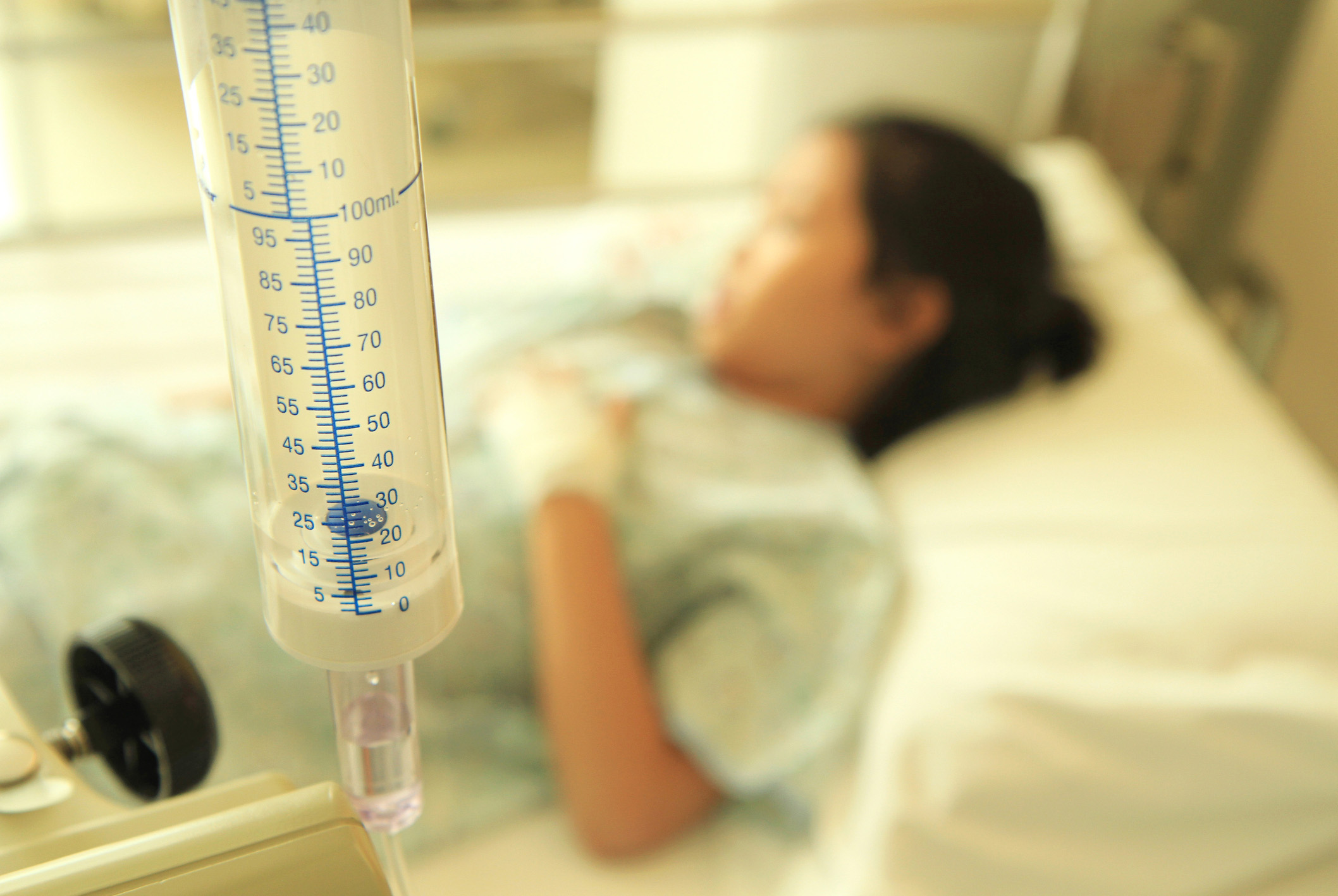 Patient on hospital bed with saline solution tube