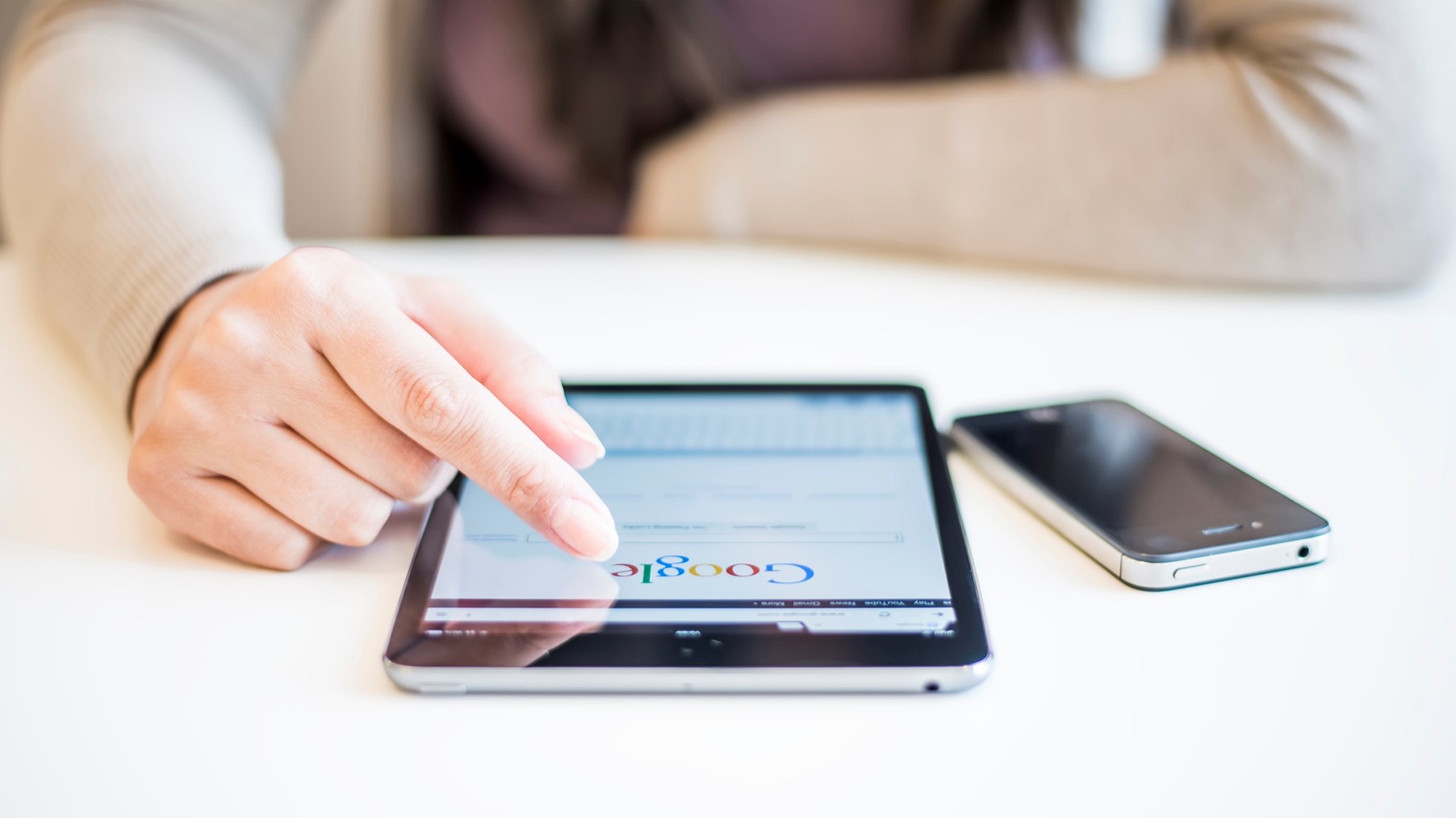 Novi Sad, Serbia - October 6, 2014: Woman's hands Googling on electronic device.Woman hands holding and touching on Apple iPad mini with Google search web page on a screen.