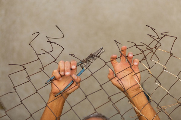 A man breaking down the fence. Immigration concept