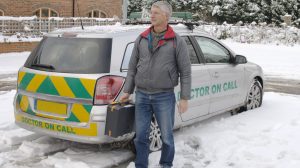 Doctor on call by vehicle in snow