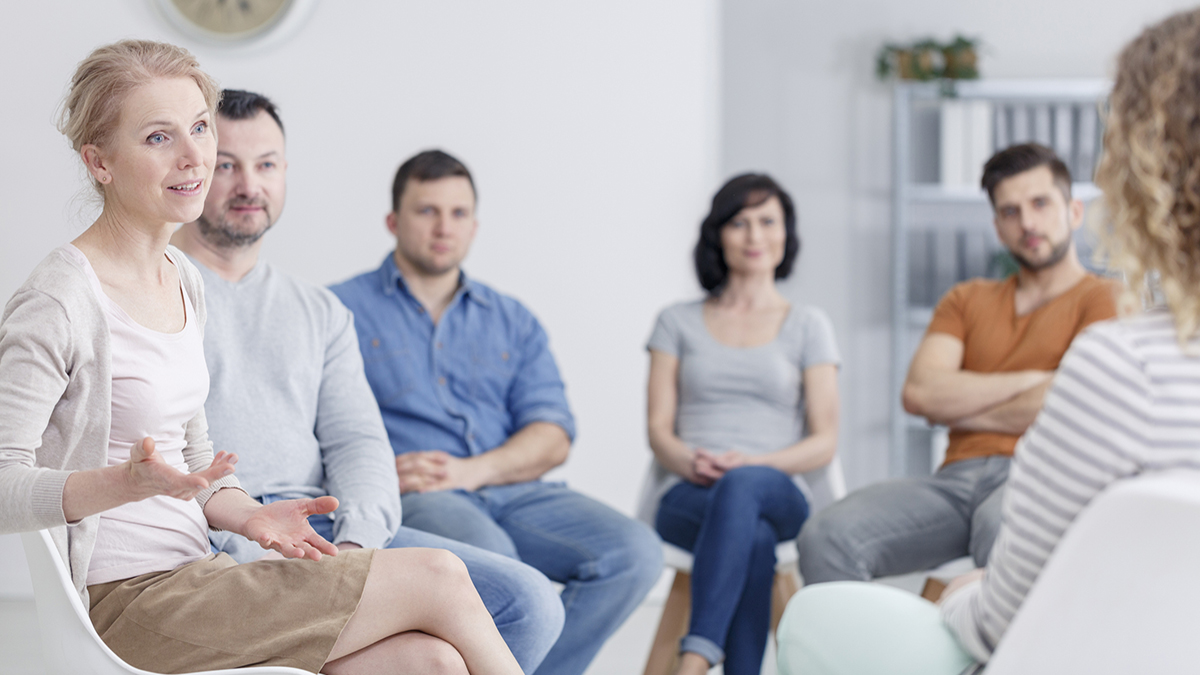 Female therapist discussing problems with her patients during a support group meeting