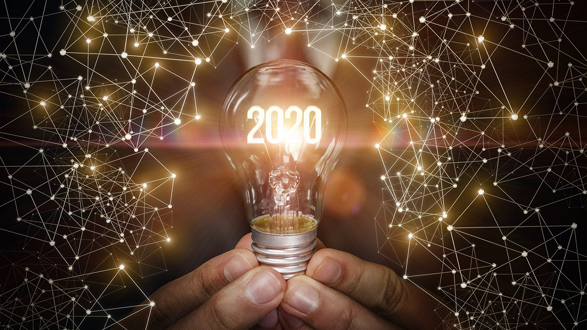 The concept of a new year with new ideas. Hand showing light bulb with luminous numbers 2020.