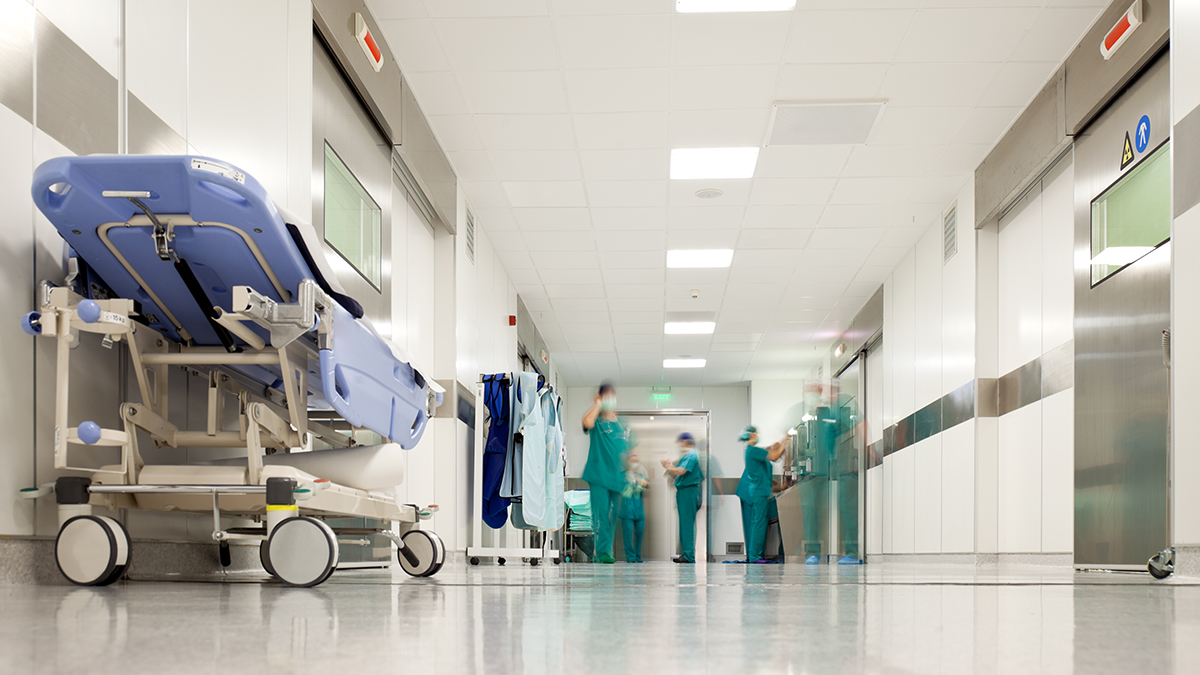 Blurred figures of people with medical uniforms in hospital corridor