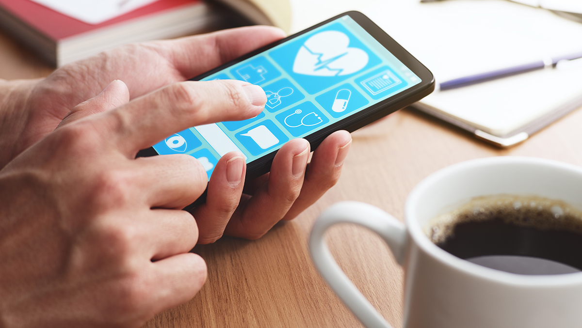 Closeup of male hands touching smartphone screen at table.